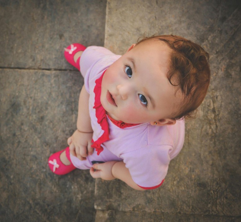 Child sits on the floor, top view.